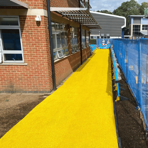 Spaghetti Trax Mat creating a high visibility yellow outdoor walkway on a construction site